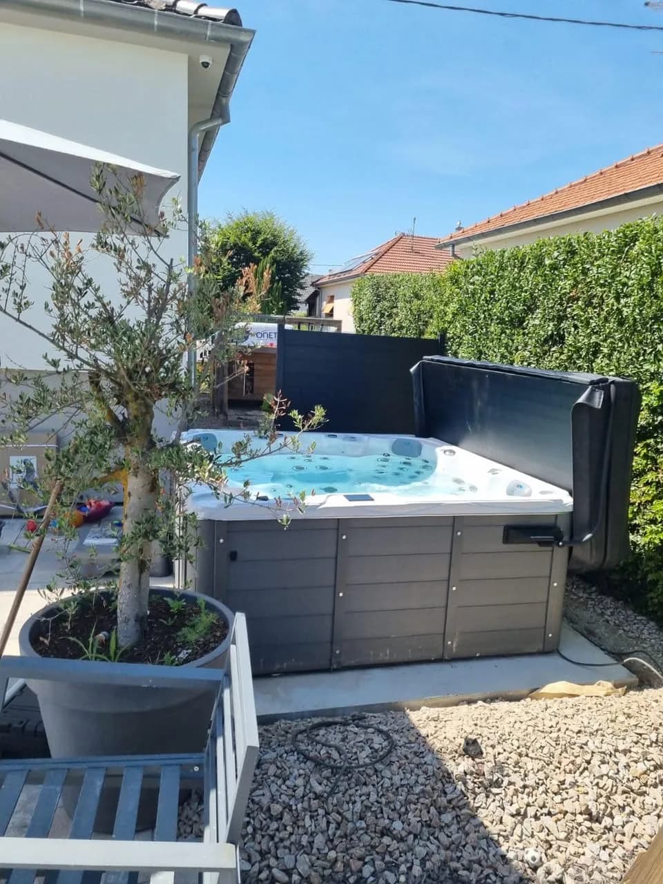 Installation d'un spa Montréal à Baldersheim, sur du gravier près d'un olivier en pot