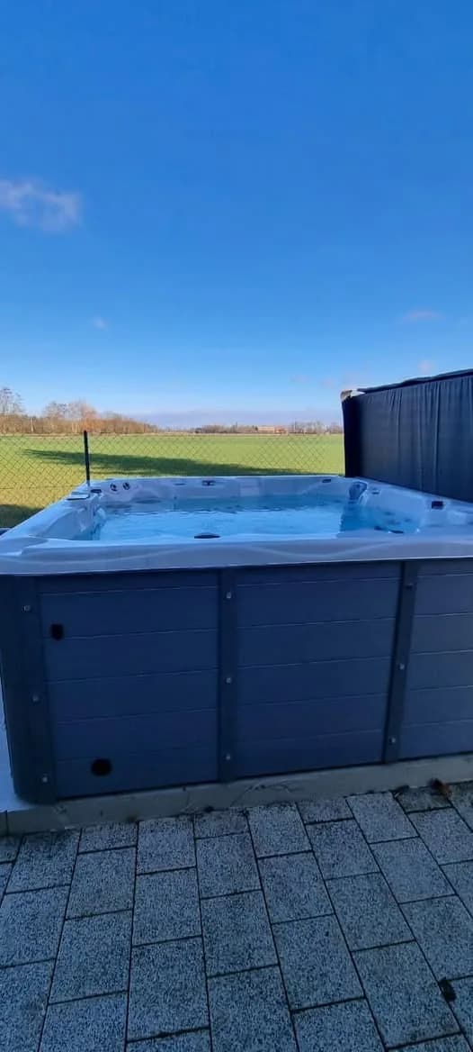 Installation d'un spa Montréal en Meurthe-et-Moselle, sur une terrasse pavée, vue sur les champs