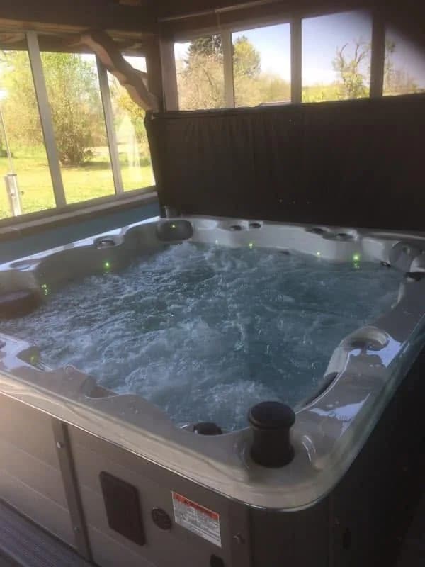 Installation d'un spa Montréal à Friesen, sous un abri, avec lève-couverture