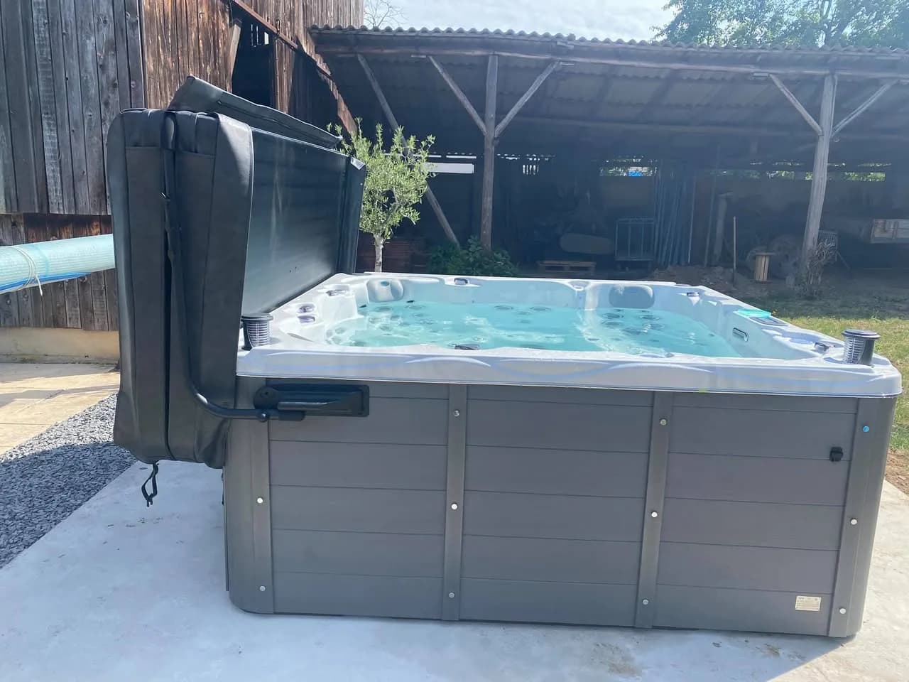Installation d'un spa Montréal Full option à Furdenheim, sur une dalle devant un abri en bois