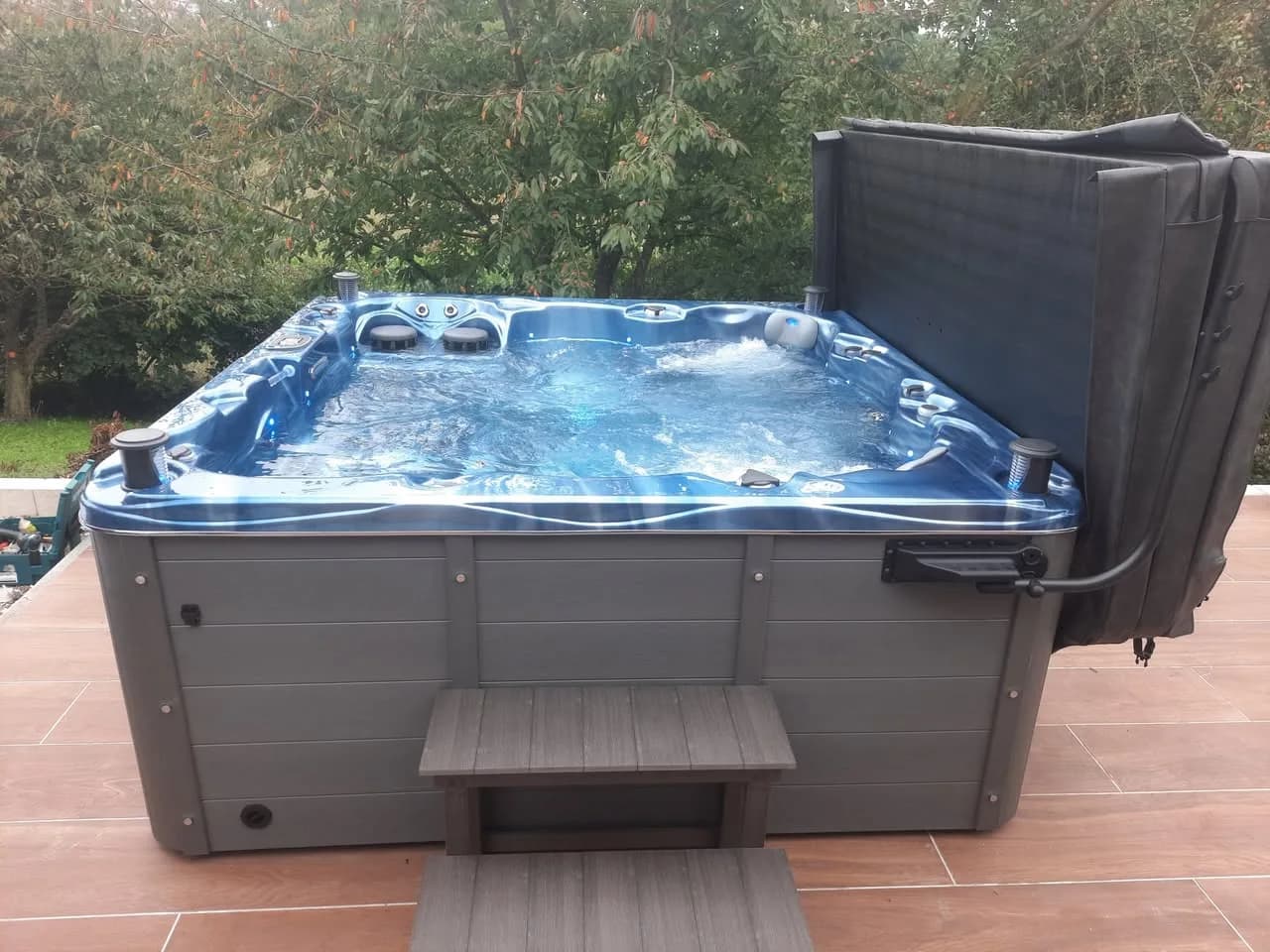 Installation d'un spa Montréal Full option à Hochfelden, sur une terrasse carrelée, lève-couverture