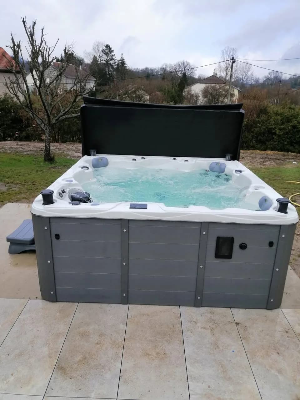 Installation d'un spa Montréal Full option à Remiremont, sur une terrasse carrelée, lève-couverture
