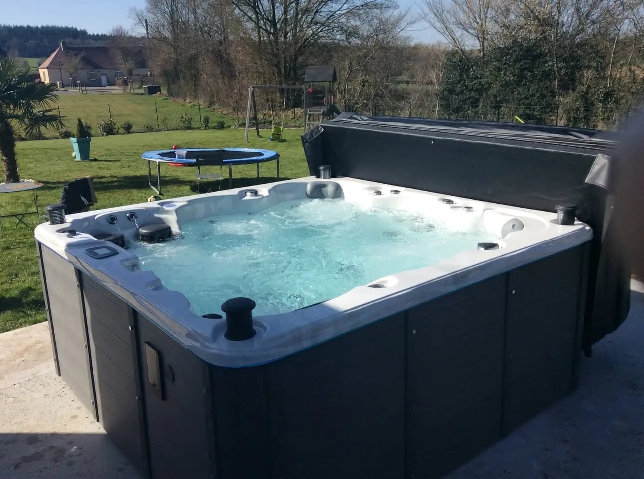 Installation d'un spa Montréal Full option à Saint-Patrice-du-Désert, sur une dalle dans un grand jardin