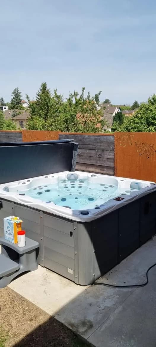 Installation d'un spa Montréal Full option à Saverne, dans un jardin devant une palissade