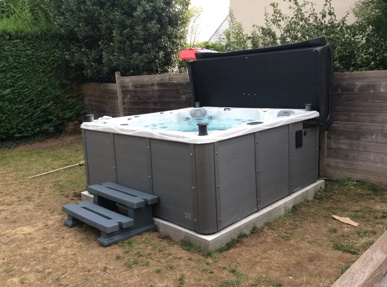 Installation d'un spa Montréal Full option à Villemoisson-sur-Orge, sur une dalle dans le jardin, avec lève-couverture