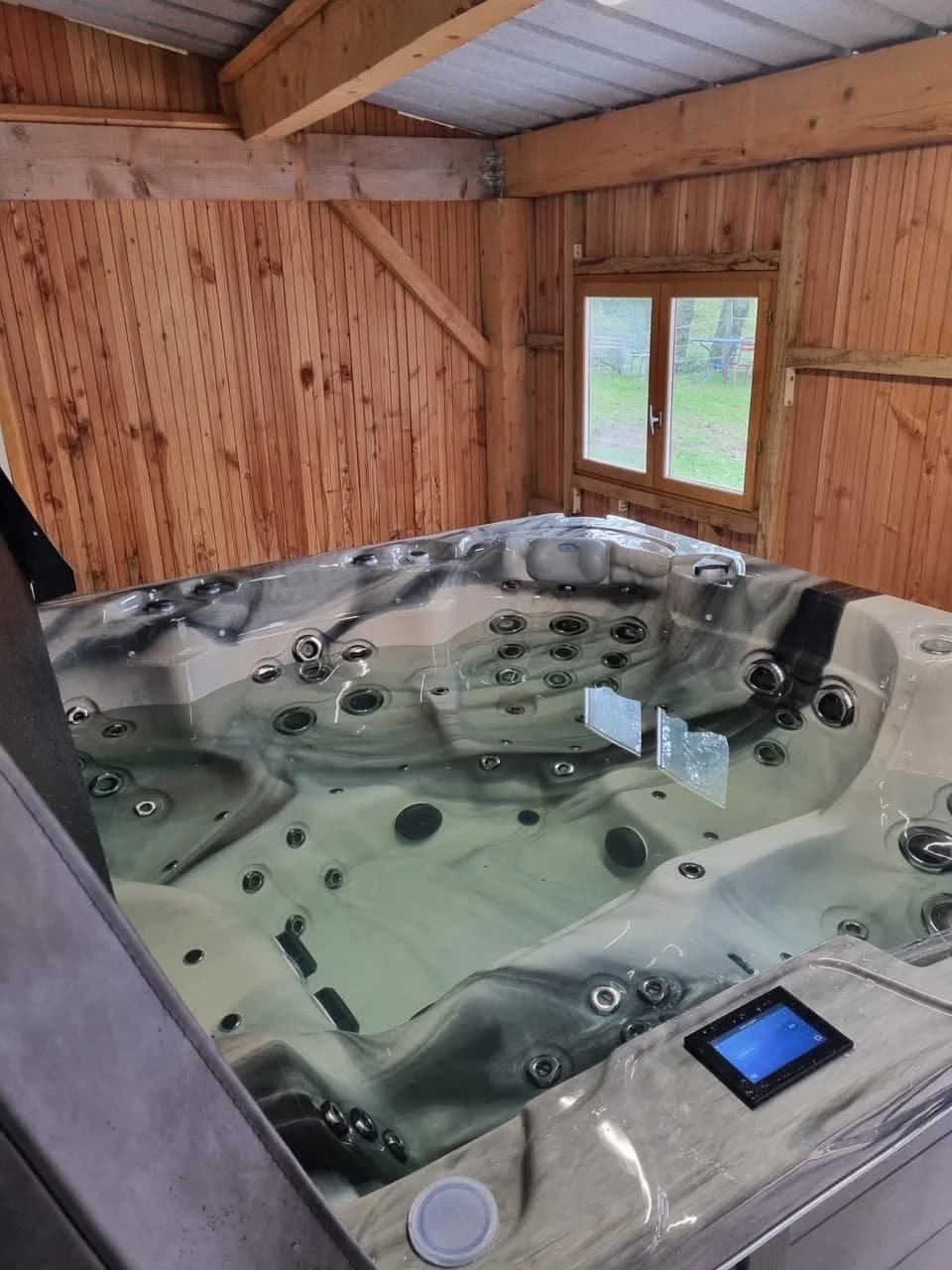 Installation d'un spa Montréal à Saulxures-sur-Moselotte, dans un abri en bois, cuve Odyssey
