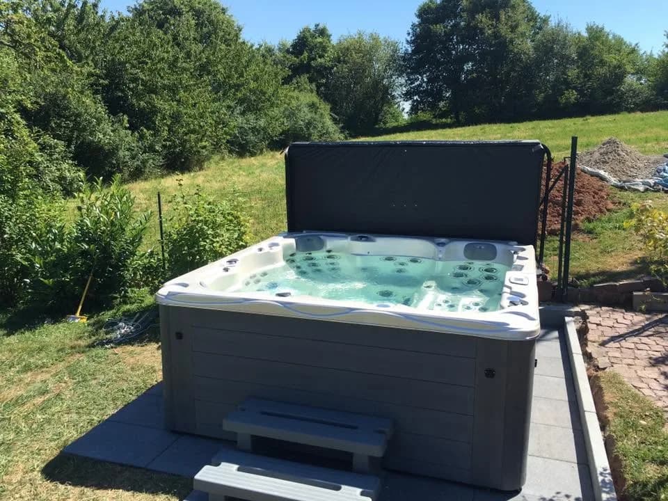Installation d'un spa Montréal à Thann, sur une dalle au milieu du gazon, marchepied