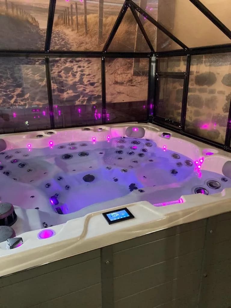Installation d'un spa Montréal à Vaux-en-Beaujolais, sous un abri vitré, éclairage LED