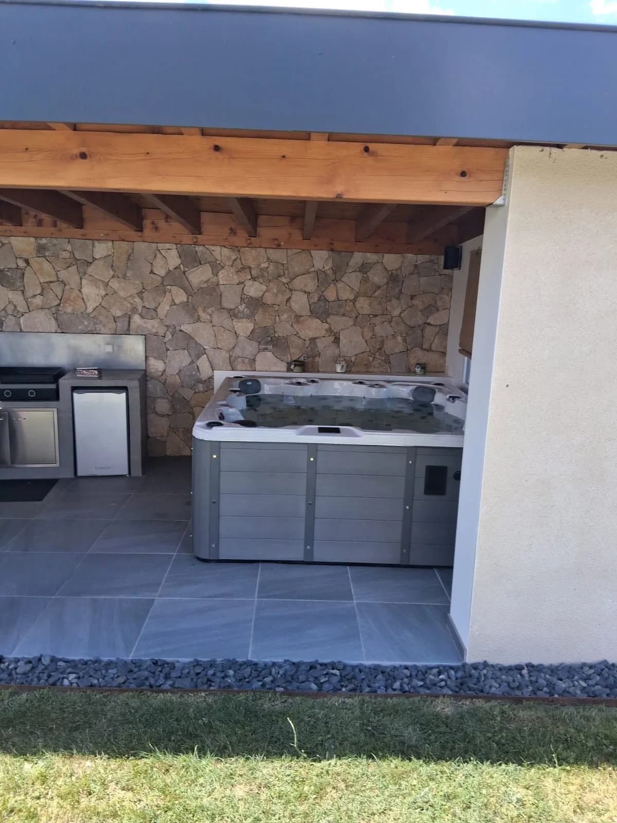 Installation d'un spa Montréal à Veauchette, dans un pool house au plafond en bois