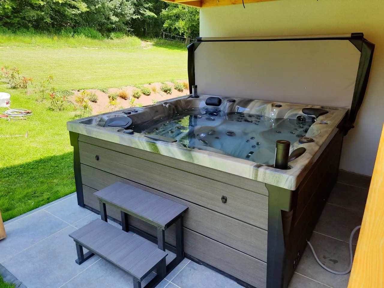 Installation d'un spa Onyx à Emlingen, sur une dalle carrelée sous un abri bardé de bois