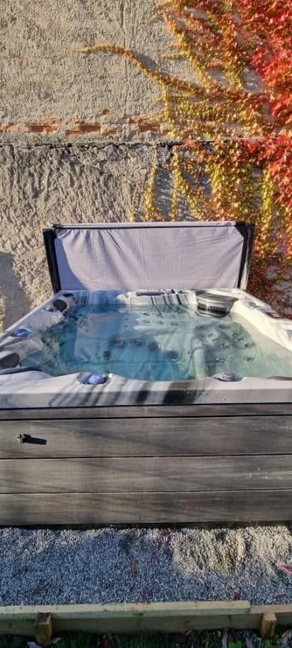 Installation d'un spa Onyx Full option à Rouffach, dans un jardin, couverture relevée