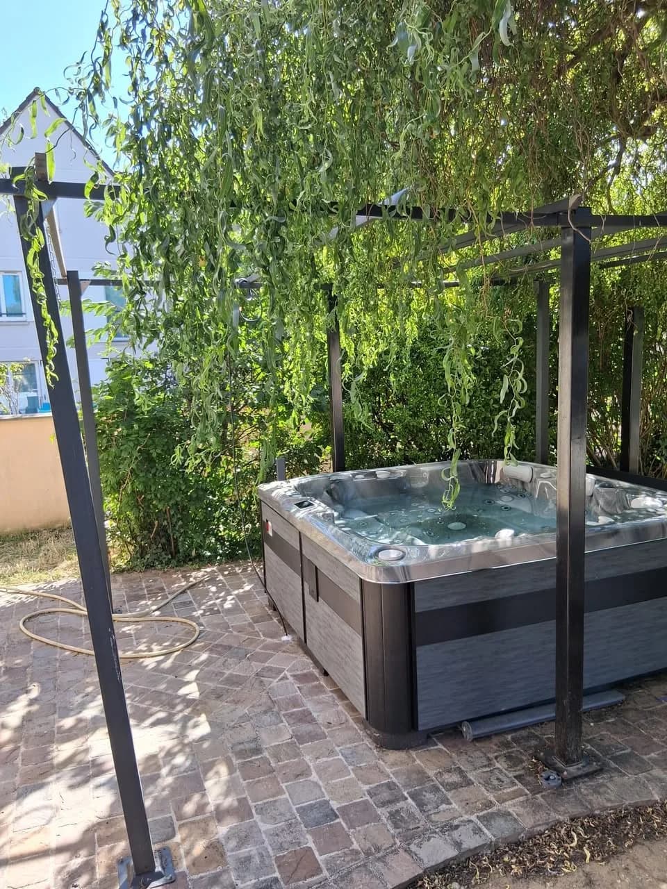 Installation d'un spa Øppland à Brétigny-sur-Orge, sur des pavés sous un saule pleureur