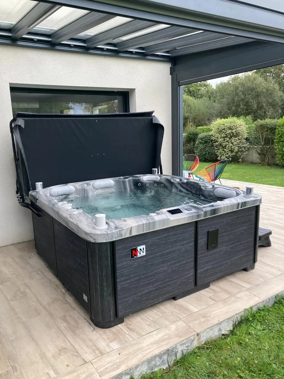 Installation d'un spa Øppland Full option à Fouesnant, sous une pergola sur une terrasse en lames