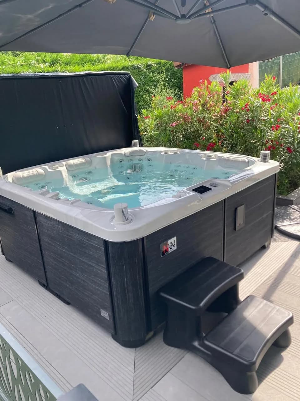 Installation d'un spa Øppland Full option à Nivolas-Vermelle, sur une terrasse sous un parasol