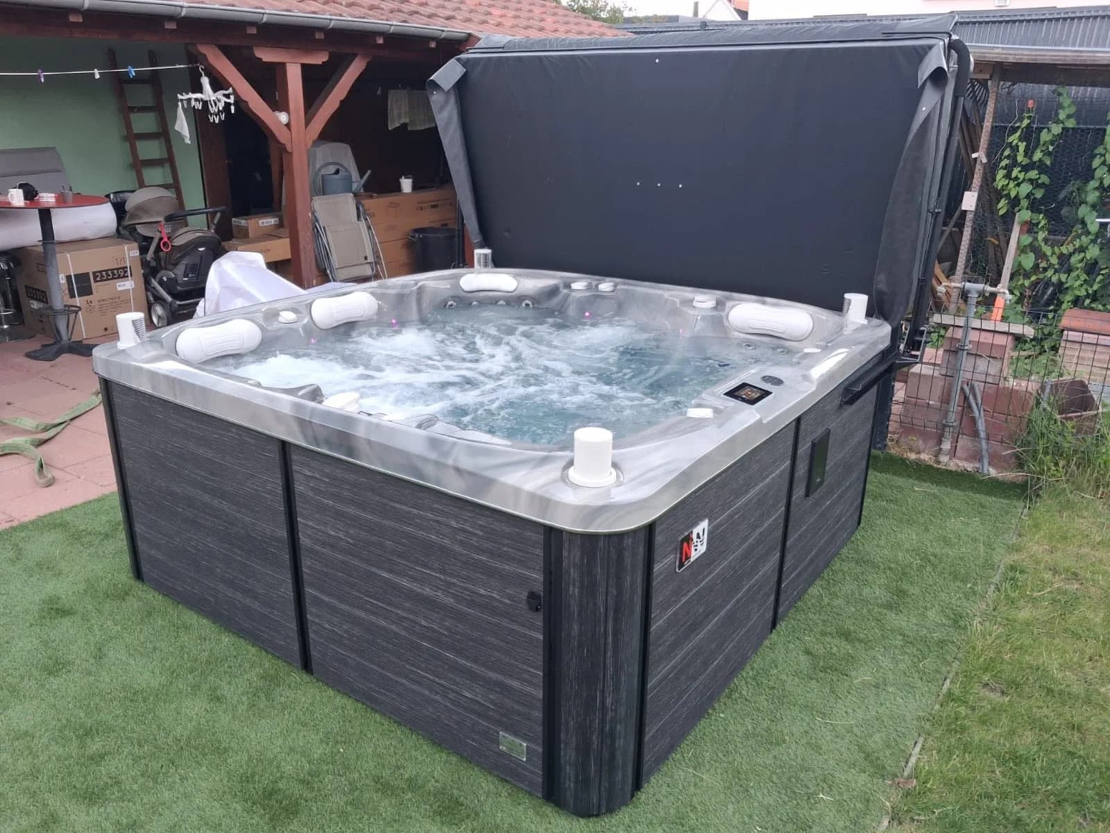 Installation d'un spa Øppland à Horbourg-Wihr, sur du gazon synthétique au milieu du jardin