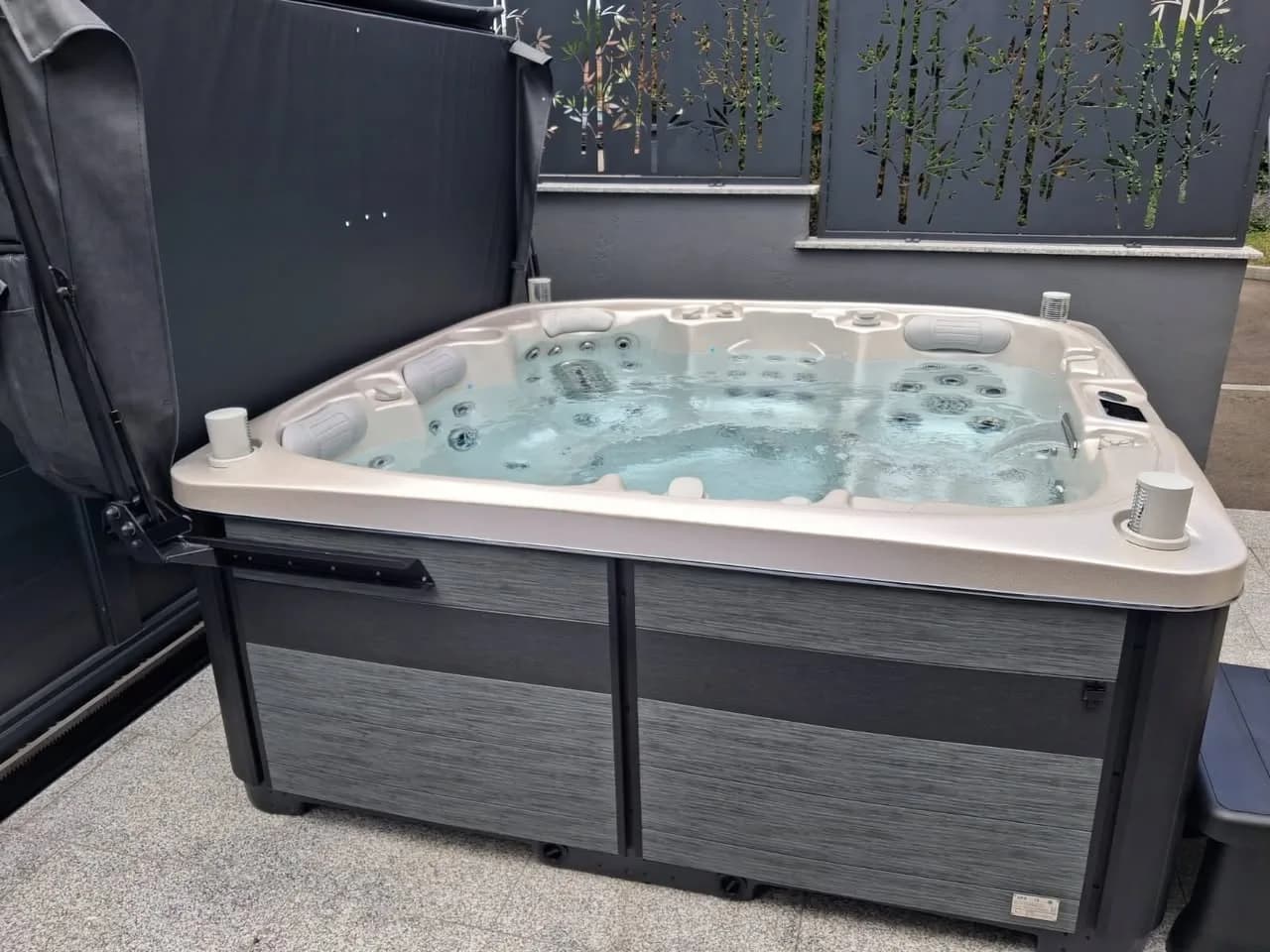 Installation d'un spa Øppland à Kingersheim, sur une terrasse dallée devant un brise-vue