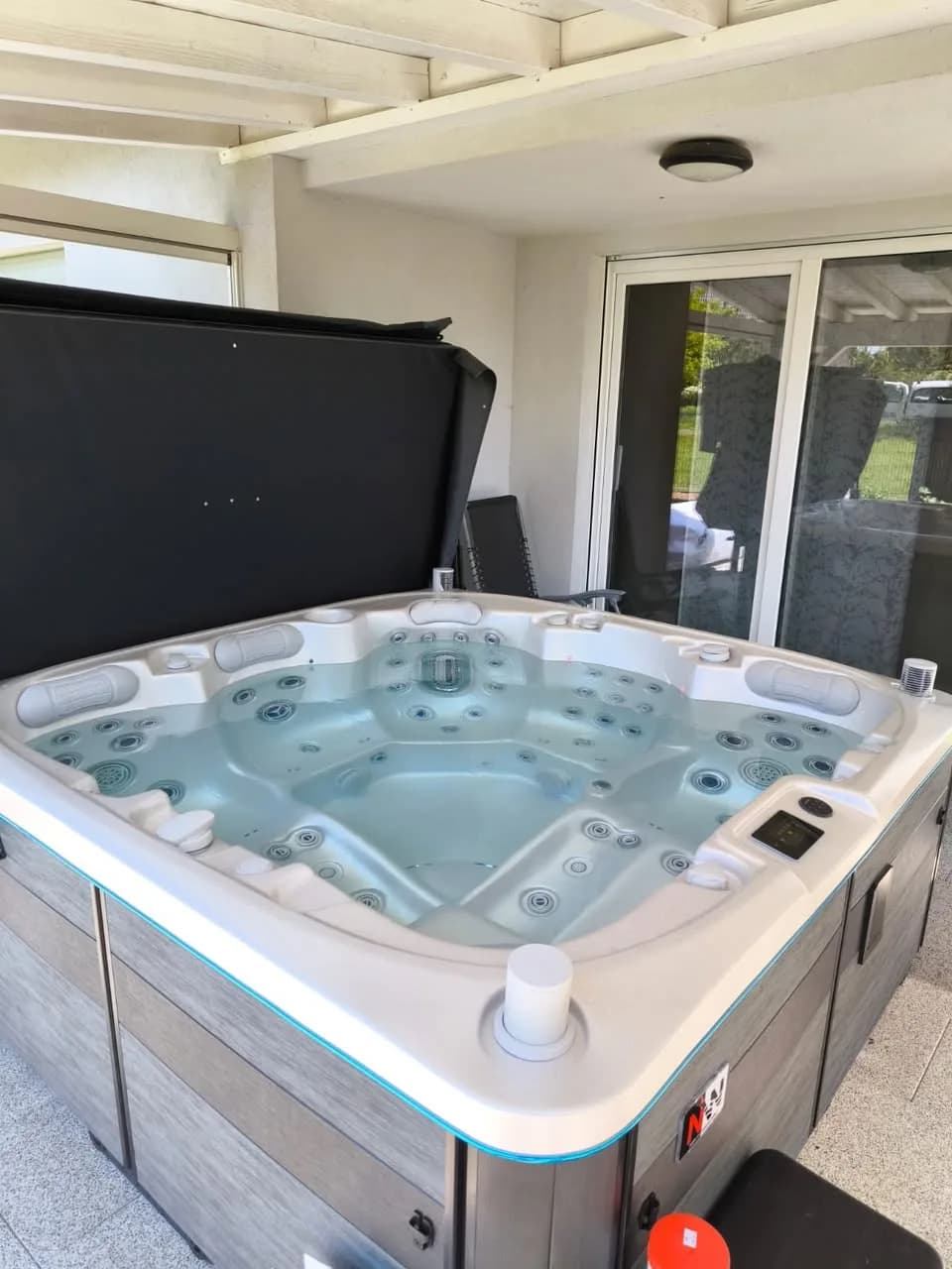 Installation d'un spa Øppland à Muespach-le-Bas, sous une terrasse couverte devant la maison