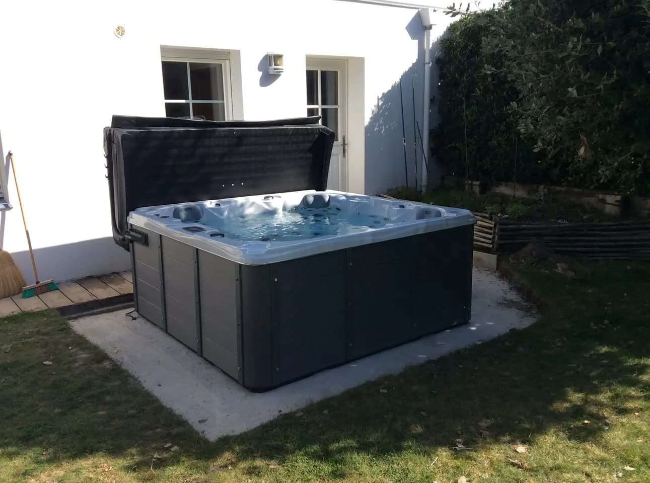 Installation d'un spa Ottawa à Arzon, sur une dalle dans un jardin, lève-couverture