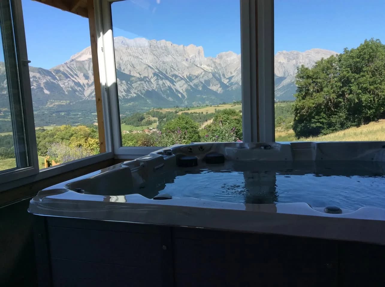 Installation d'un spa Ottawa à Barcillonnette, sous une véranda, face aux montagnes