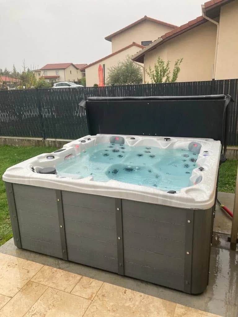 Installation d'un spa Ottawa à Chatte, sur un dallage en pierre claire, marchepied