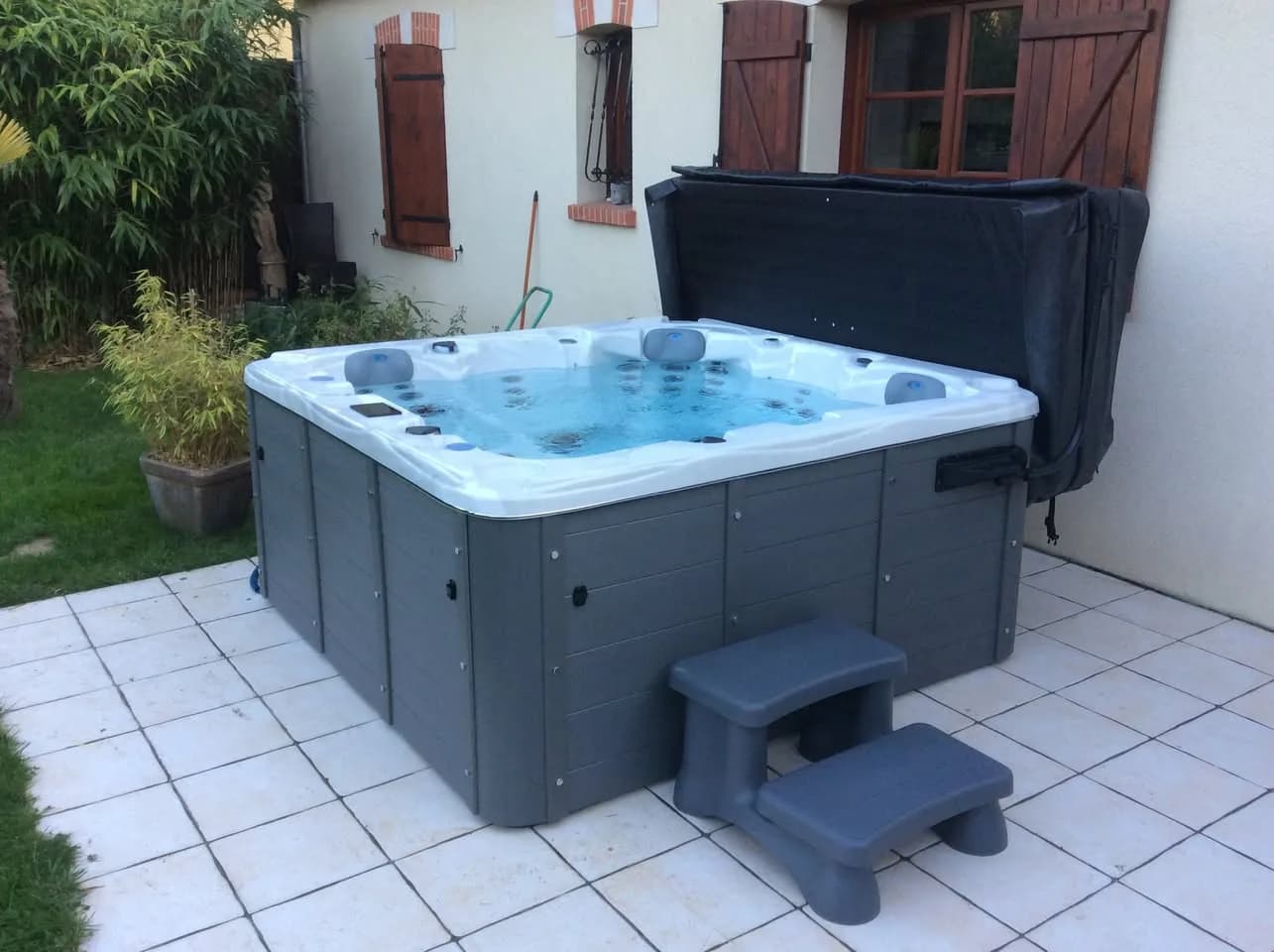 Installation d'un spa Ottawa à Corquilleroy, sur une terrasse carrelée, lève-couverture et marchepied