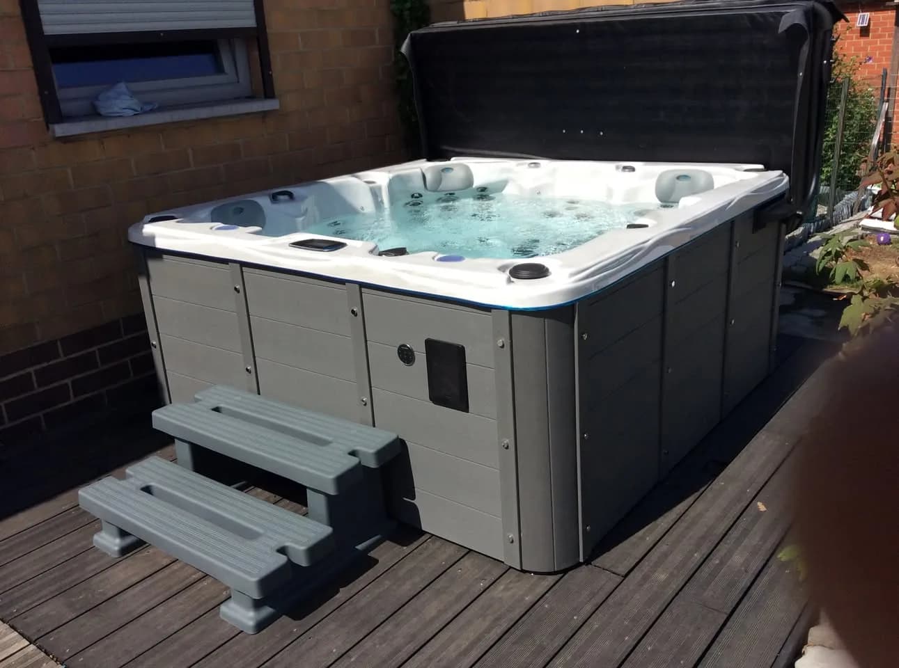 Installation d'un spa Ottawa en Belgique, sur une terrasse en bois, avec marchepied