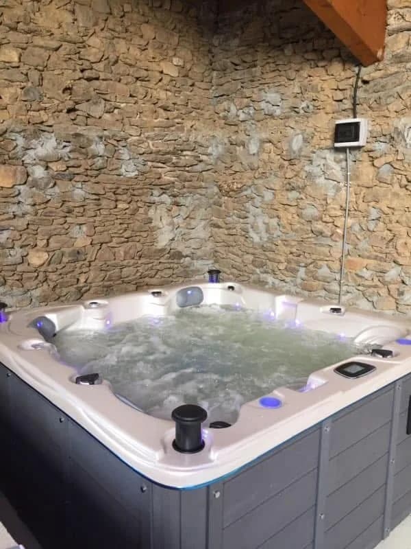 Installation d'un spa Ottawa Full option dans le Rhône, contre un mur en pierre, éclairage LED