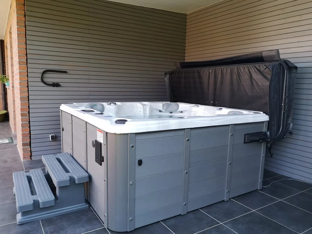 Installation d'un spa Ottawa Full option à Havinnes, sur une terrasse couverte, avec marchepied