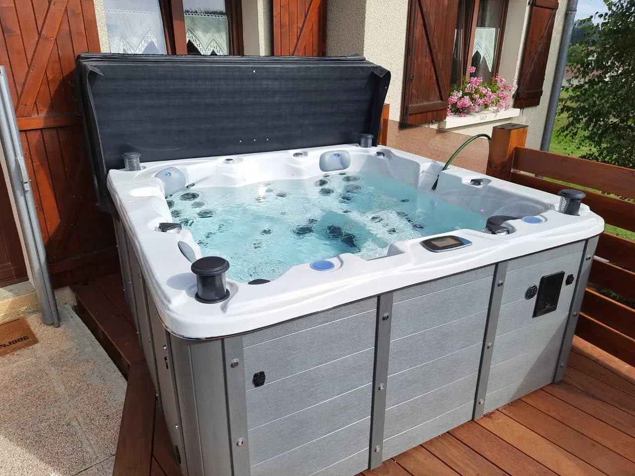 Installation d'un spa Ottawa Full option à Les Combes, sur une terrasse en bois, lève-couverture