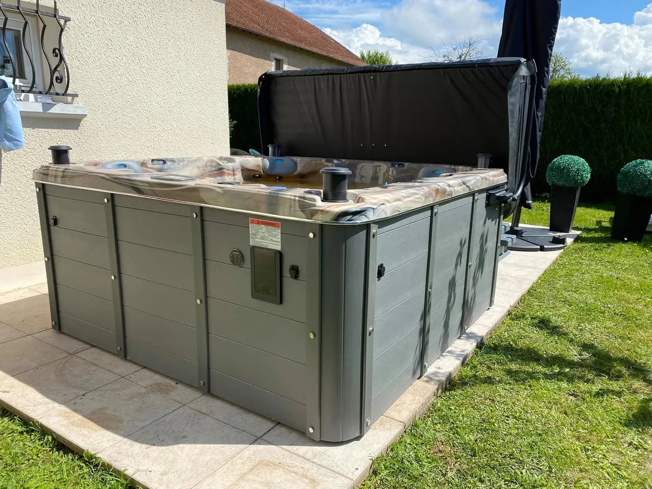 Installation d'un spa Ottawa Full option à Lure, sur une dalle dans un jardin, avec lève-couverture