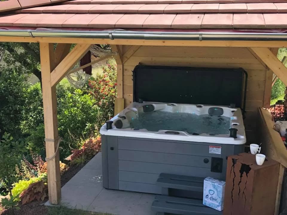 Installation d'un spa Ottawa Full option à Moosch, sous un kiosque en bois couvert de tuiles
