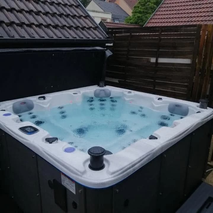 Installation d'un spa Ottawa Full option à Mulhouse, devant une palissade en bois
