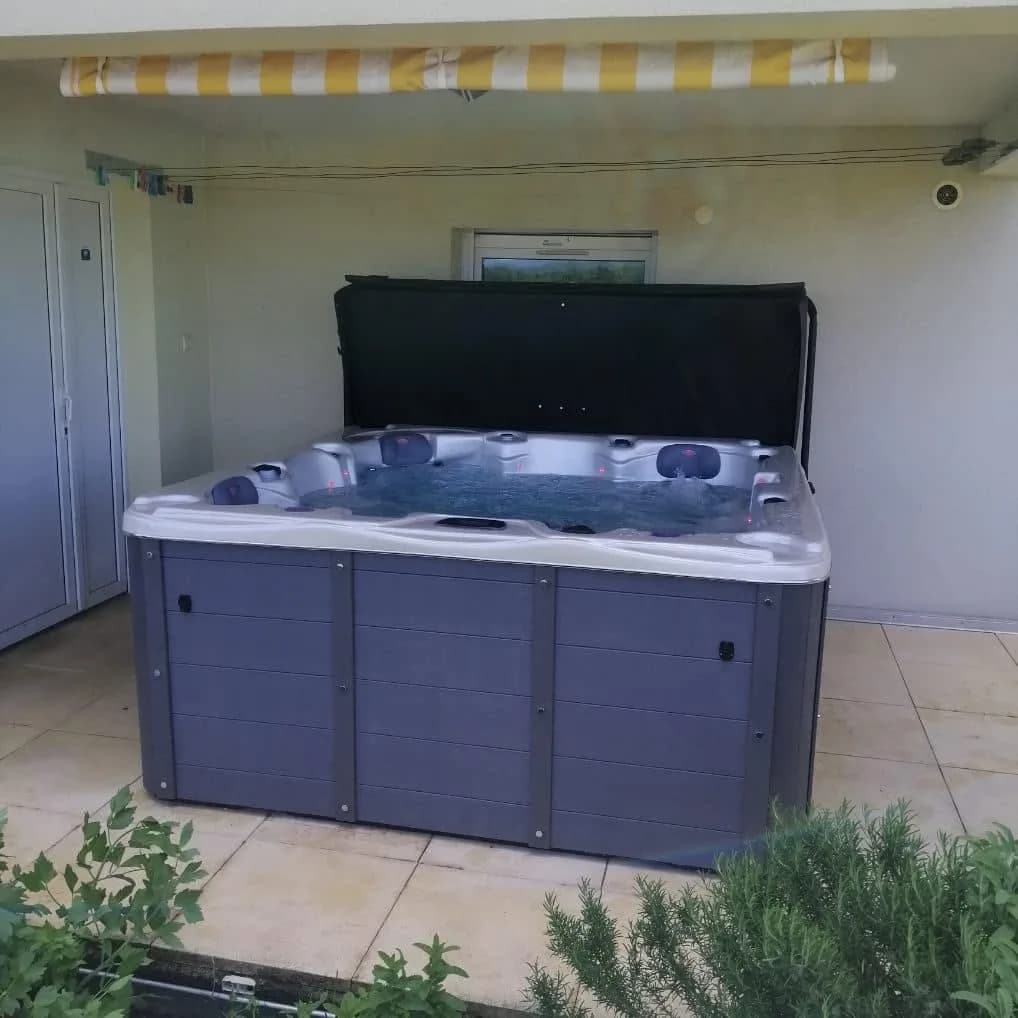 Installation d'un spa Ottawa à Pulversheim, sur une terrasse carrelée sous un store