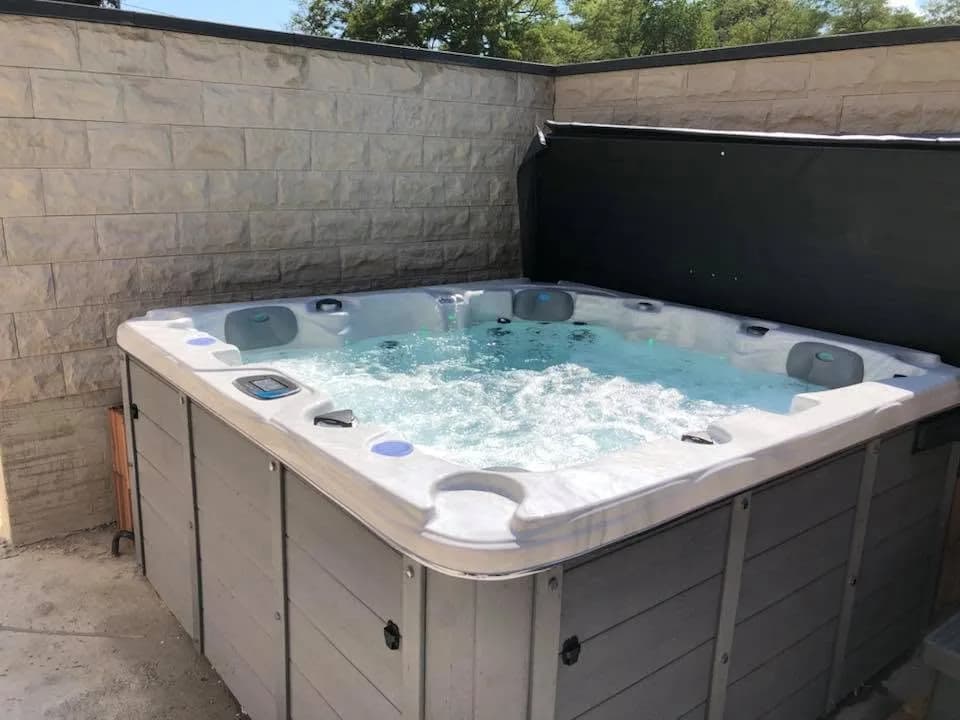 Installation d'un spa Ottawa à Rouffach, contre un mur en pierre de parement