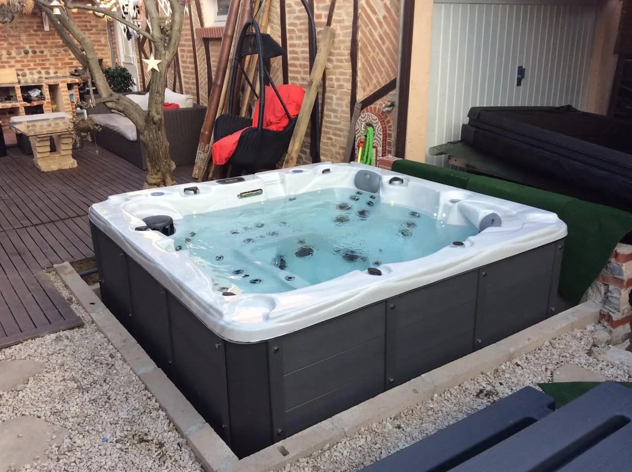 Installation d'un spa Ottawa à Toulouse, sur une terrasse en bois, à côté d'un olivier