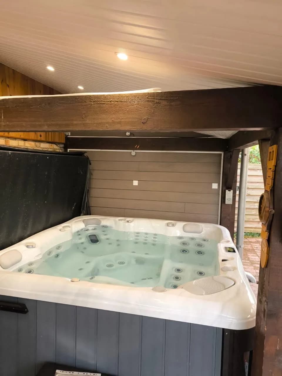 Installation d'un spa Poséidon à Audincourt, sous une terrasse couverte, sol pavé