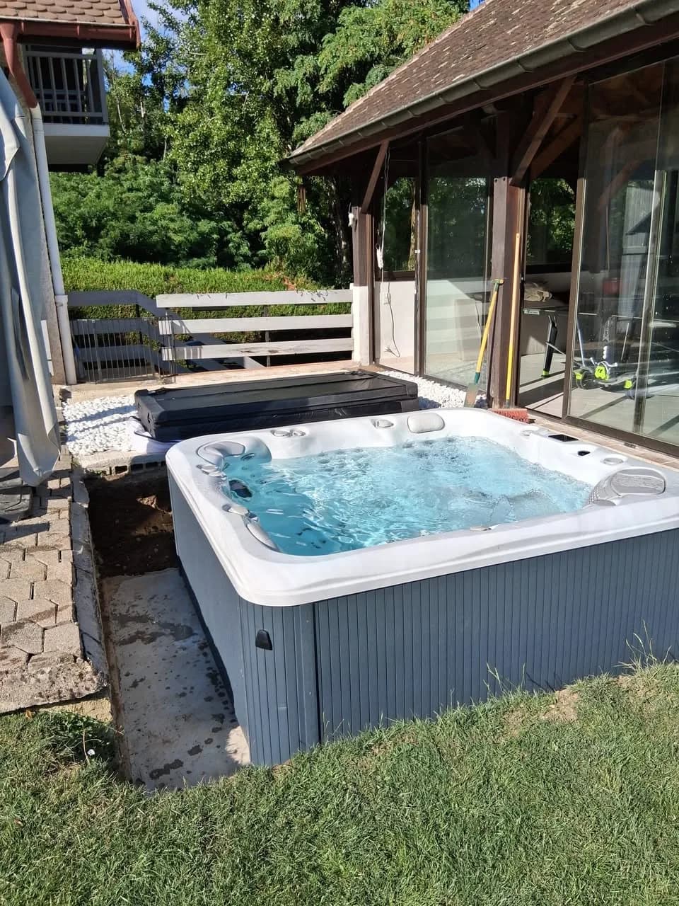 Installation d'un spa Poséidon Full option à Divonne-les-Bains, sur la pelouse au pied d'une terrasse