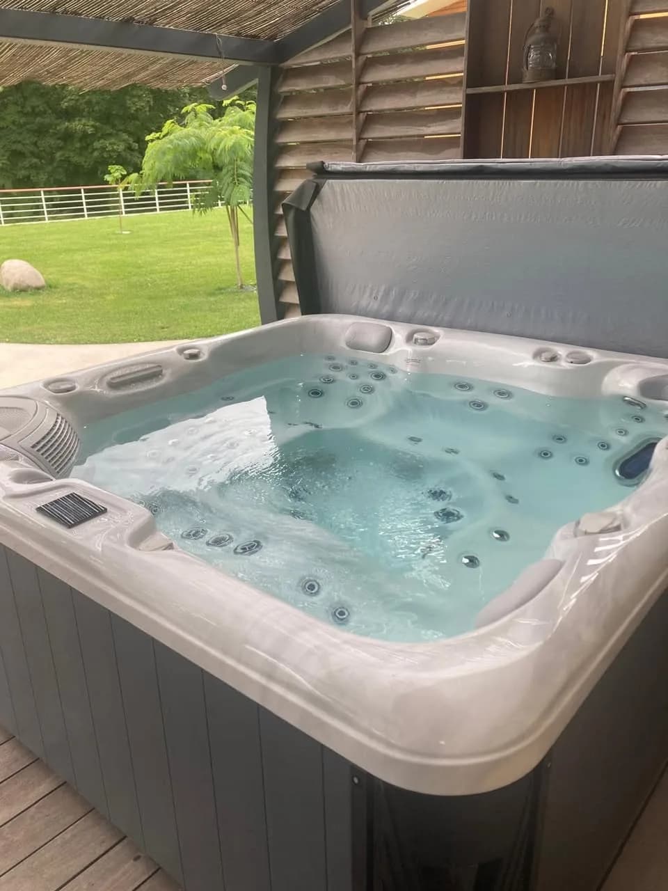 Installation d'un spa Poséidon Full option à Joinville, sur une terrasse en bois face au jardin