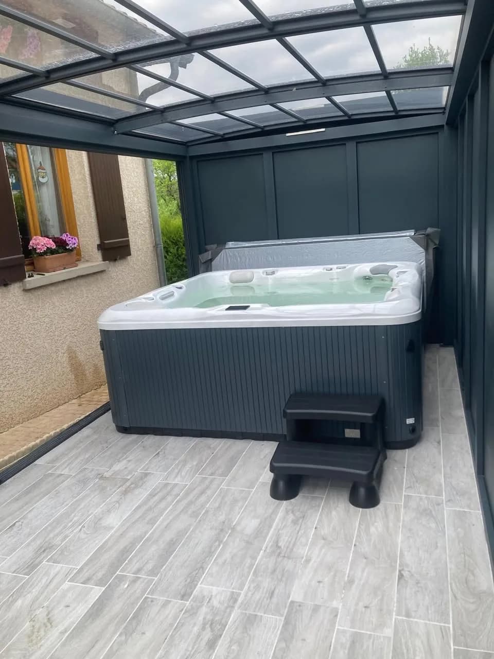 Installation d'un spa Poséidon Full option à Resson, sous une véranda, sol carrelé