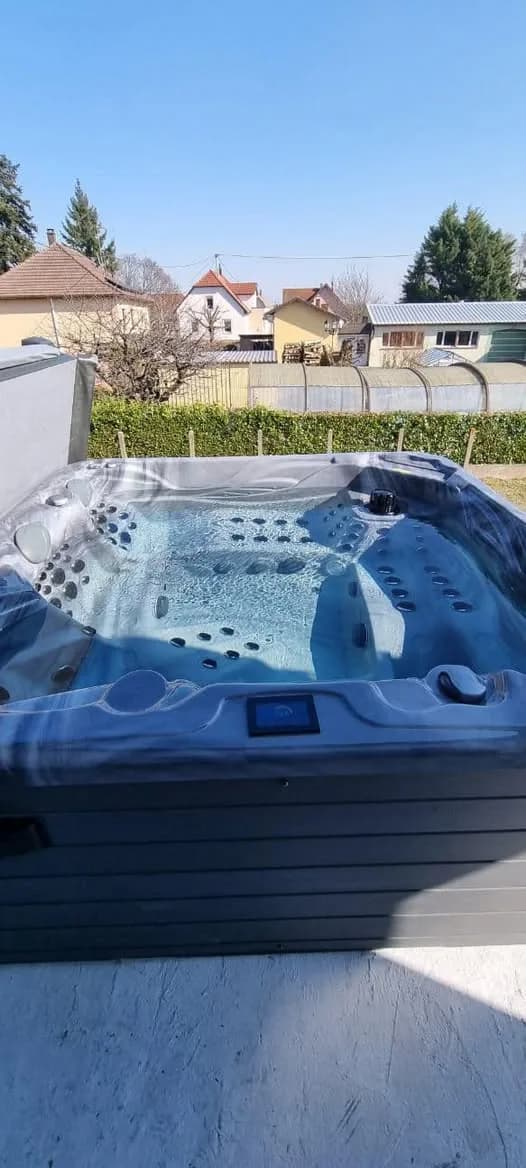Installation d'un spa Poséidon à Issenheim, dans un jardin, cuve marbrée grise