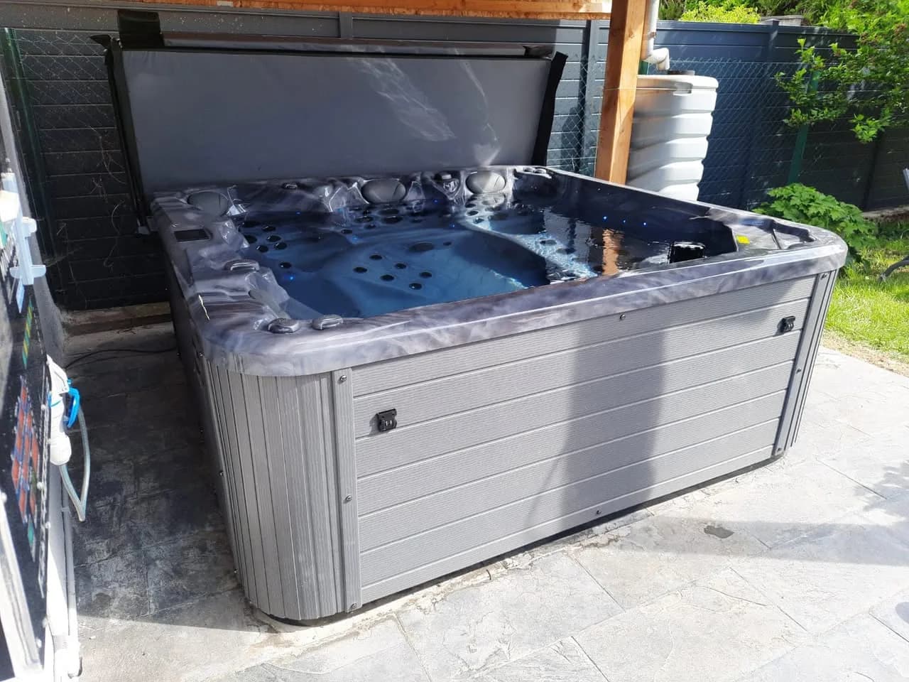 Installation d'un spa Poséidon à Mulhouse, sur un sol en ardoise sous un abri