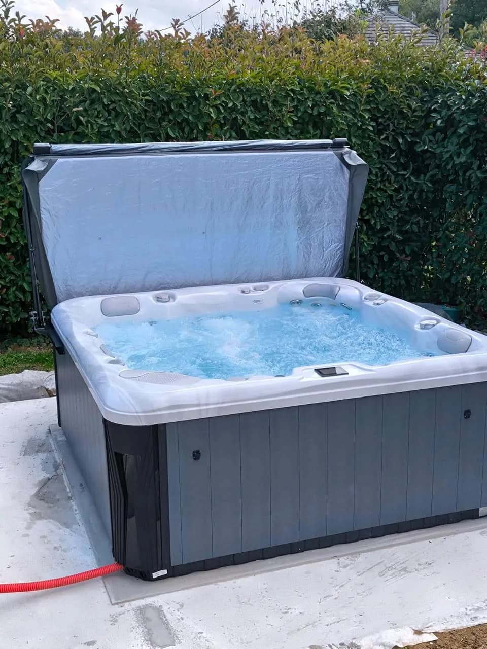 Installation d'un spa Poséidon à Schweighouse, sur une dalle neuve devant une haie