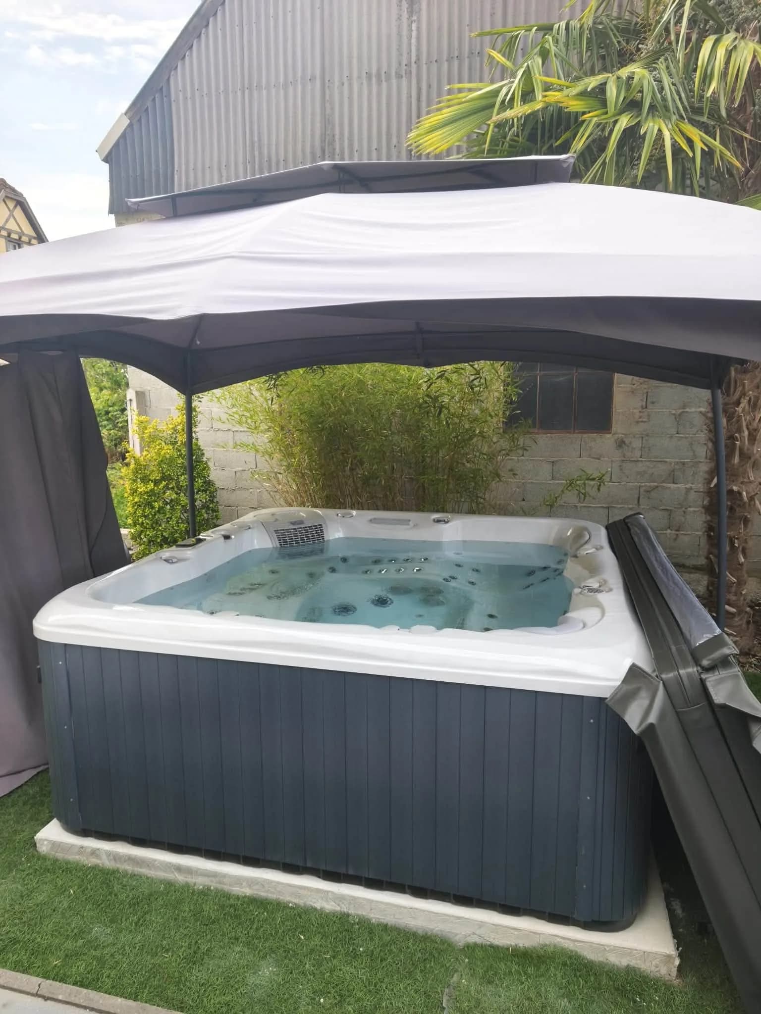 Installation d'un spa Poséidon à Sermersheim, sous une tonnelle, au bord d'un gazon synthétique