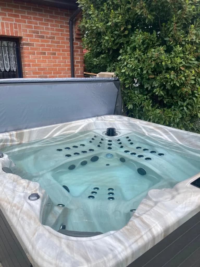 Installation d'un spa Poséidon à Wambrechies, dans un jardin près d'une maison en brique