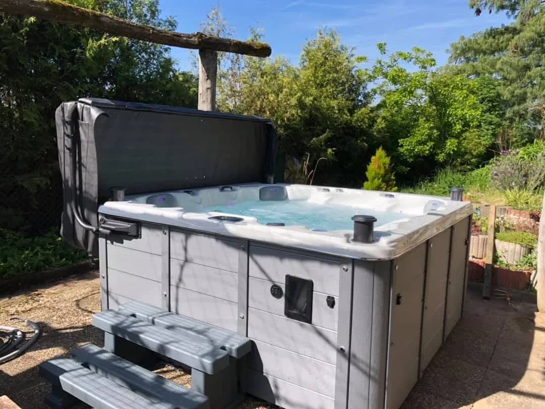 Installation d'un spa Québec Full option à Chavannes-sur-l'Étang, dans le jardin sous une pergola en bois brut