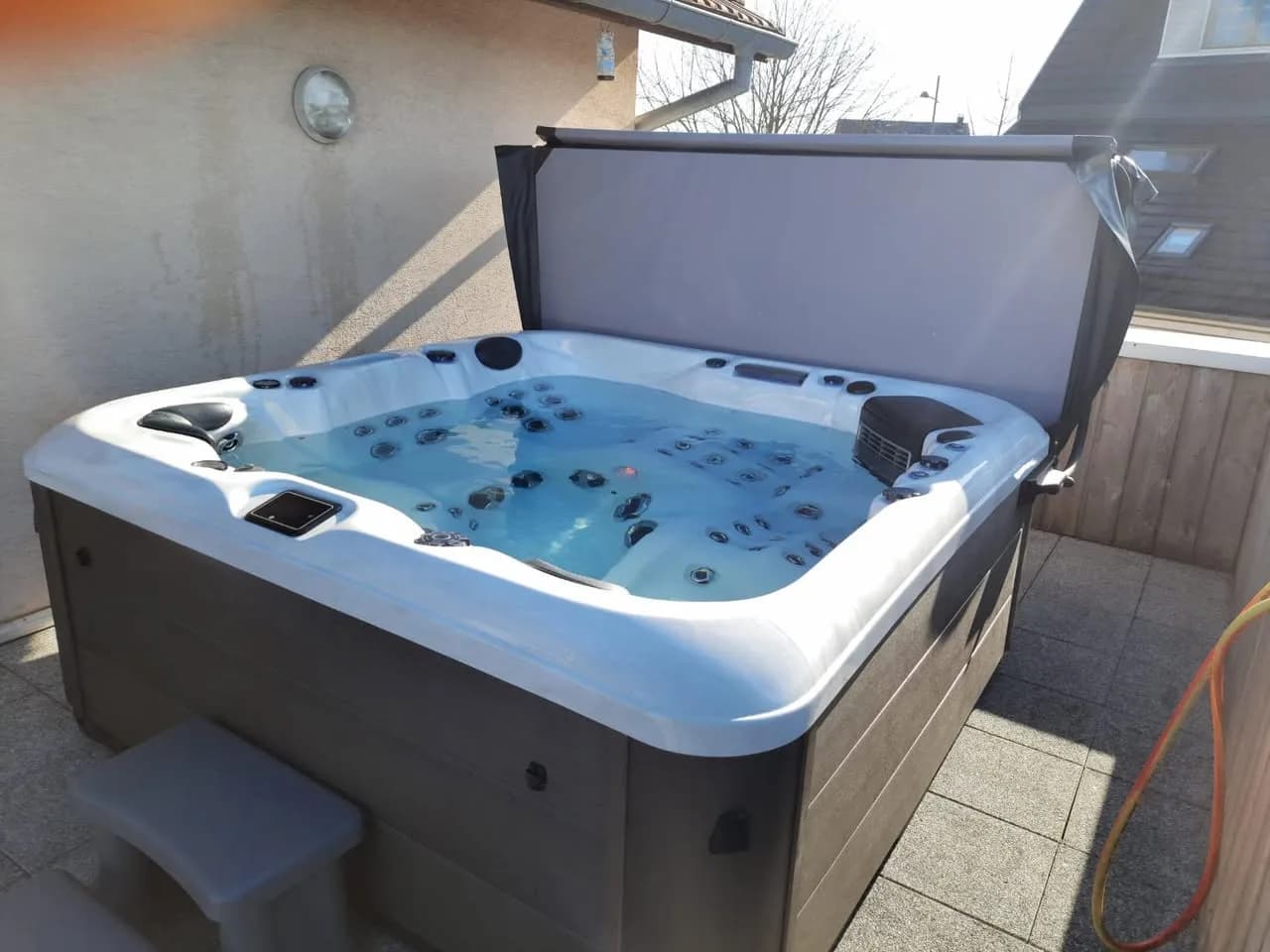 Installation d'un spa RC7 Full option à Burnhaupt-le-Haut, sur une terrasse, lève-couverture
