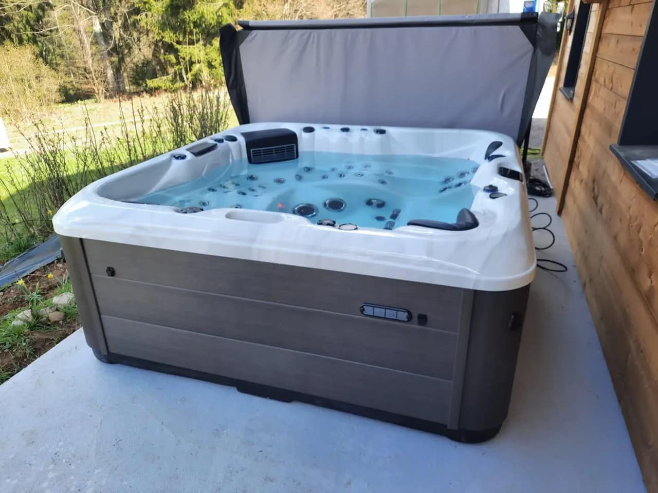 Installation d'un spa RC7 à Gérardmer, sur une dalle contre un chalet en bois