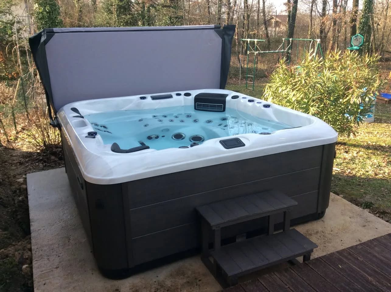 Installation d'un spa RC7 à Mensignac, sur une dalle dans un jardin, marchepied