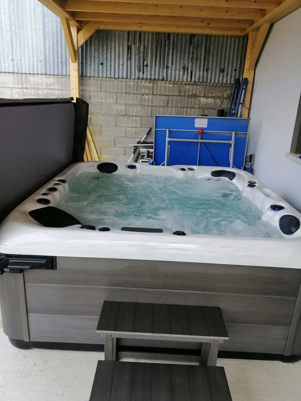 Installation d'un spa RC7 à Munwiller, sous un auvent en bois, marchepied