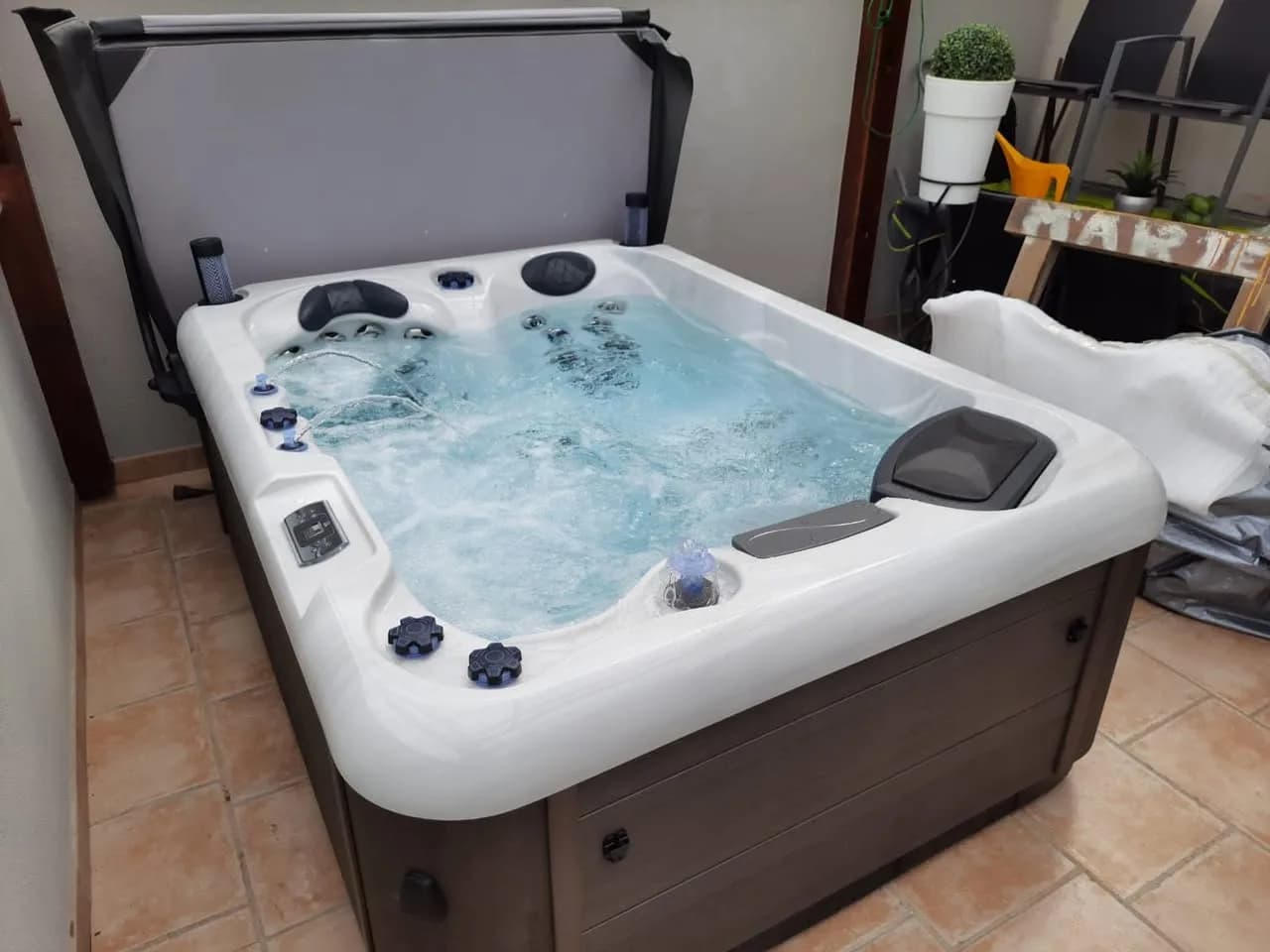 Installation d'un spa RC7 à Pfaffenheim, sur une terrasse carrelée, lève-couverture